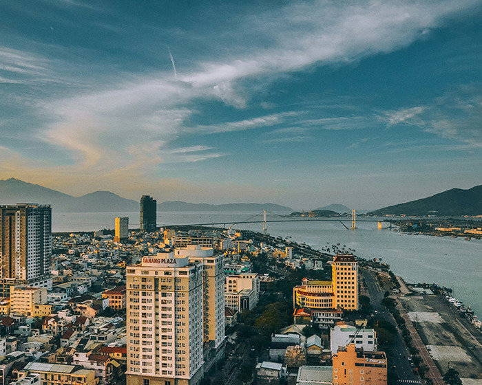 Cityscape of Da Nang, Vietnam, with buildings and the river under a cloudy sky, related to plastic surgery travel risks. Cityscape of Da Nang, Vietnam, with buildings and the river under a cloudy sky, related to plastic surgery travel risks.