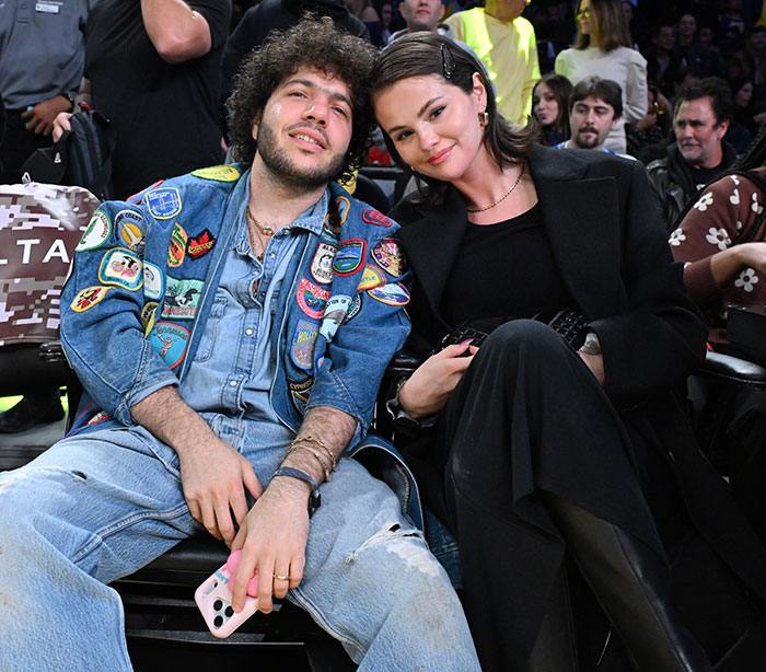 Benny Blanco and Selena Gomez sitting together at an event, capturing fans’ reactions to his cold treatment. Benny Blanco and Selena Gomez sitting together at an event, capturing fans’ reactions to his cold treatment.