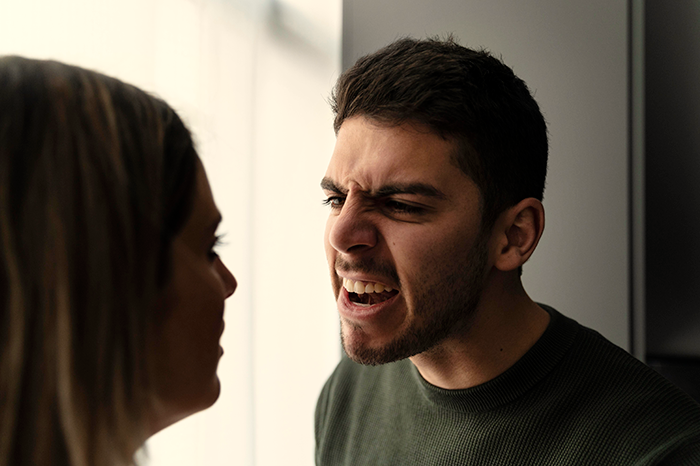 Upset boyfriend angrily confronting his girlfriend in an intense moment between a couple obsessed with relationship conflict.