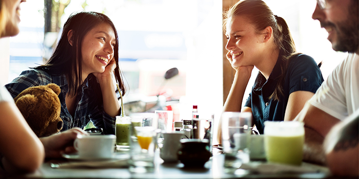 Young couple at a cafe, boyfriend upset while girlfriend appears obsessed, sharing an intense moment over drinks.