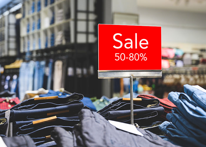 Clothing store sale sign showing 50-80 percent off, revealing industry secrets customers rarely know.