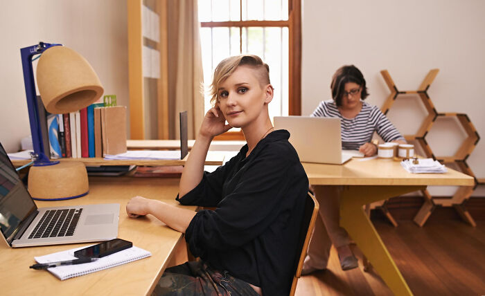 Young woman sitting at desk with laptop, symbolizing the biggest bullet dodged without realizing it at the time.