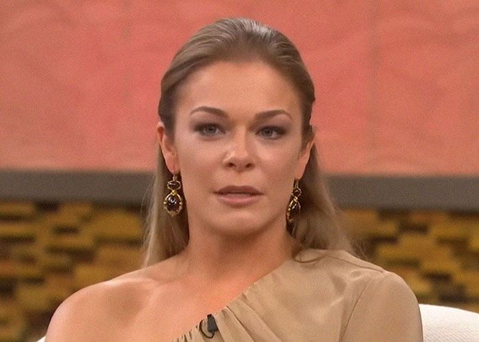 Mujer con expresión seria en programa de televisión, ilustrando momentos de traición y backstabbing en Hollywood.