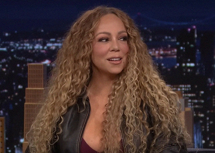 Mariah Carey con cabello rizado largo y chaqueta negra hablando sobre traición y momentos de backstabbing en Hollywood.