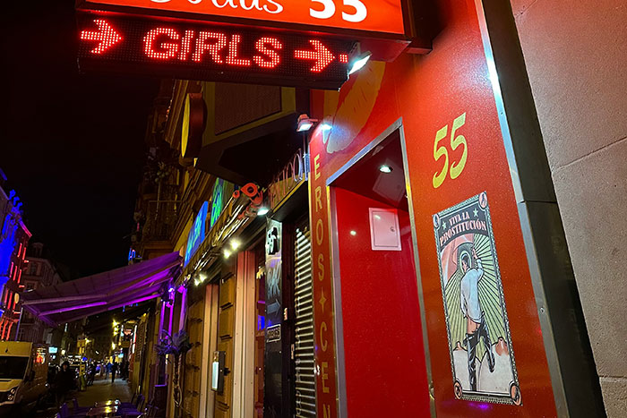Neon sign outside an adult entertainment venue at night, symbolizing deepest secrets people refuse to reveal to parents.