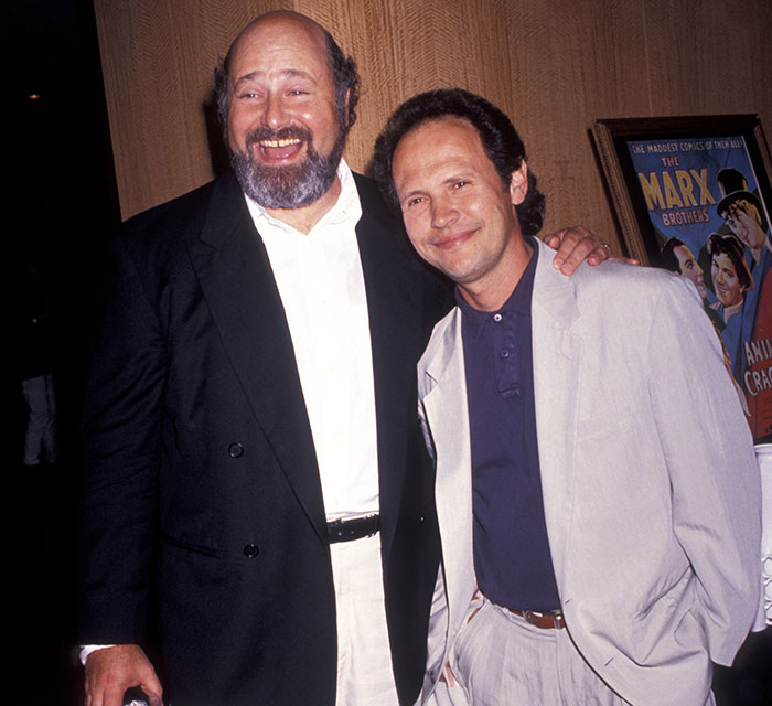 Two men smiling and posing together at an event, representing Rob Reiner’s close friend Billy Crystal after visiting crime scene. Two men smiling and posing together at an event, representing Rob Reiner’s close friend Billy Crystal after visiting crime scene.