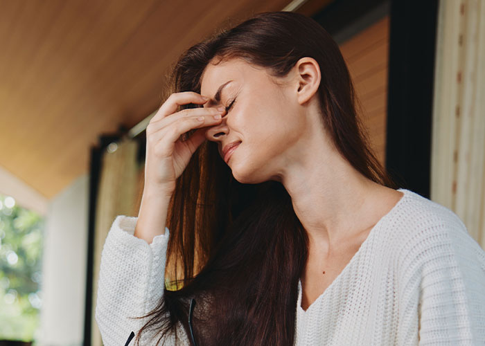Woman rethinking her engagement looking distressed after fianc&eacute;&rsquo;s lie about her family causes tension during holiday dinner