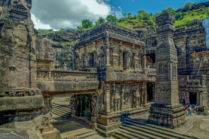 Ancient rock-cut temple with intricate carvings and sculptures, a real place that looks AI generated.