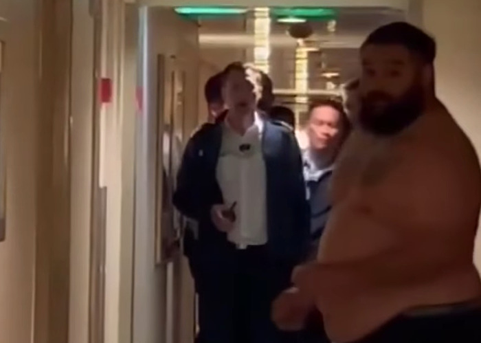 Cruise passenger's body inside a fridge after being fatally served 33 drinks shown in a crowded ship hallway.