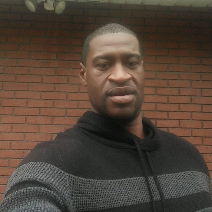 Man wearing black and gray sweater standing in front of a brick wall, related to cruise passenger body incident.