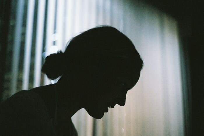 Silhouette of a person in profile with a nose ring, backlit by soft window light, evoking curiosity and introspection about life facts.