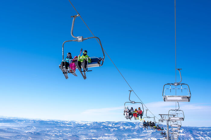 People riding a ski lift over snowy mountains, illustrating life-changing moments from small decisions and unexpected consequences.