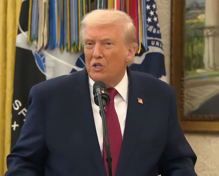 Donald Trump speaking at a podium with flags in the background addressing comments involving Rob Reiner.