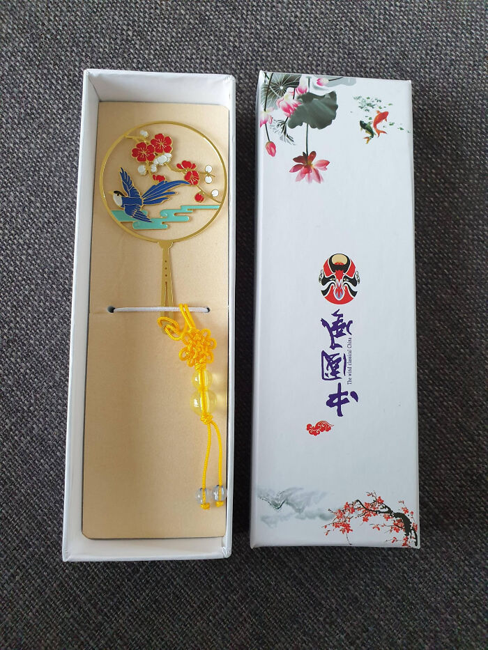 Bizarre Christmas gift showing a decorative fan with floral and bird design in a traditional style box.