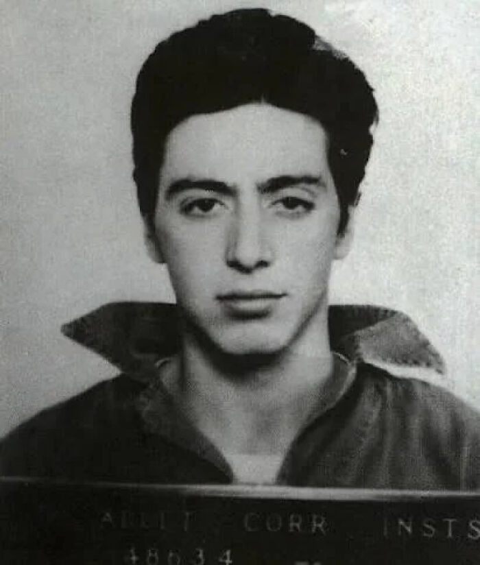 Vintage black and white mugshot of a young male celeb after being arrested, showing a serious expression and dark hair.