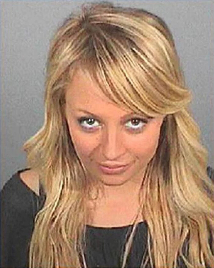 Young blonde woman with long hair in a black top, mugshot photo after being arrested among celebs mugshot collection.