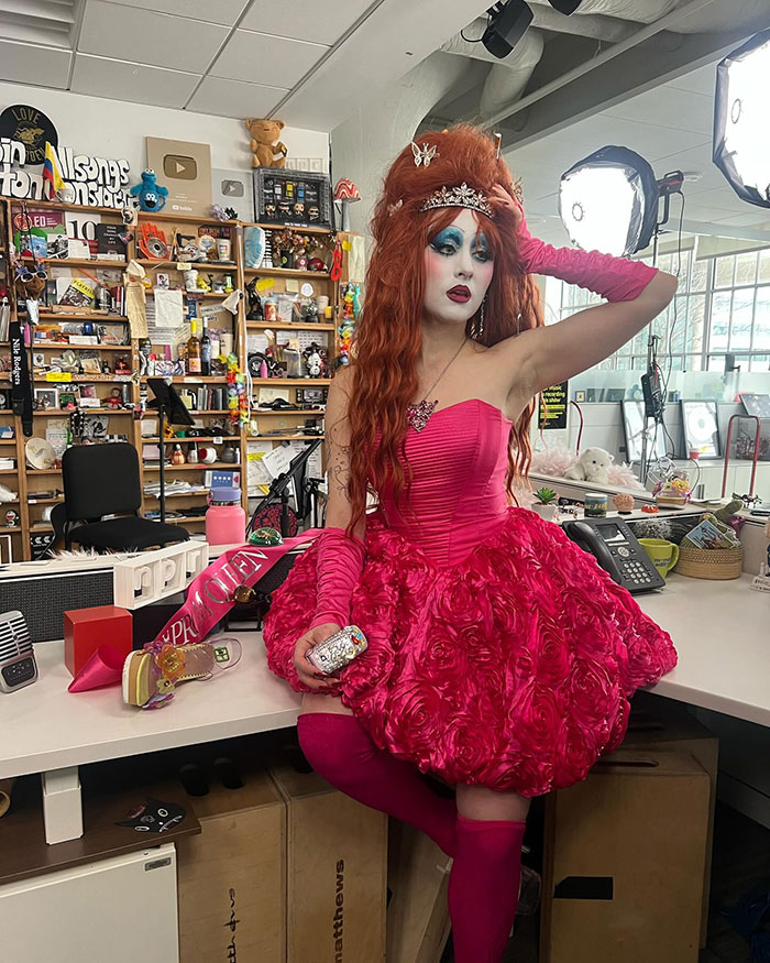 Chappell Roan in a pink dress and dramatic makeup, posing amid studio equipment and awards, facing Brigitte Bardot backlash. Chappell Roan in a pink dress and dramatic makeup, posing amid studio equipment and awards, facing Brigitte Bardot backlash.