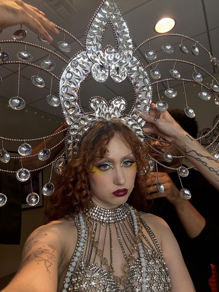 Chappell Roan wearing elaborate jeweled costume and headpiece, preparing backstage amid final touches. Chappell Roan wearing elaborate jeweled costume and headpiece, preparing backstage amid final touches.