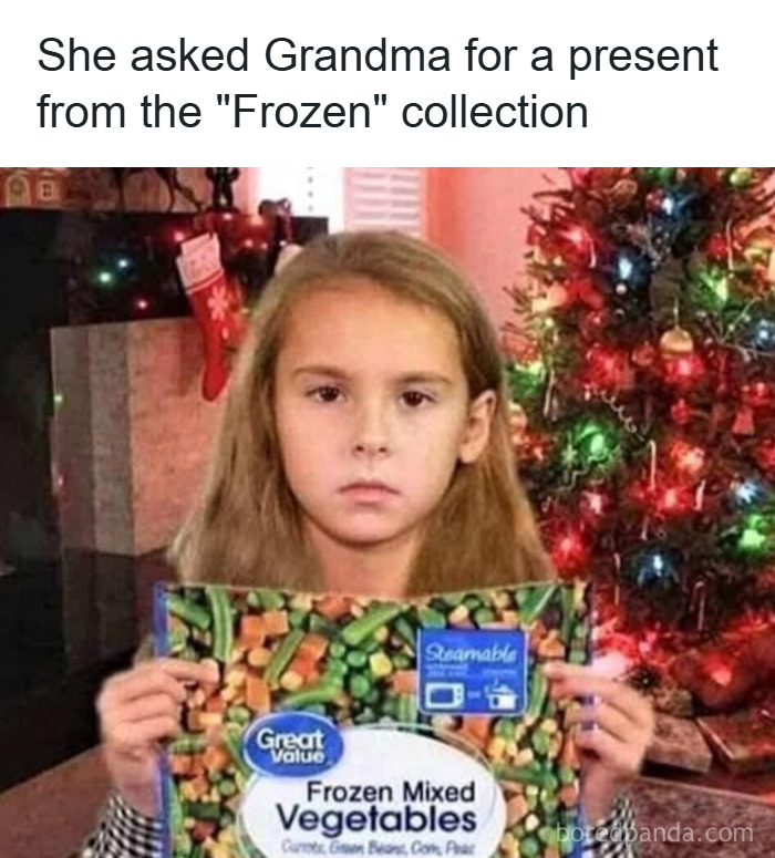 Young girl holding a frozen vegetable bag looking disappointed near Christmas tree in funny Christmas memes context.
