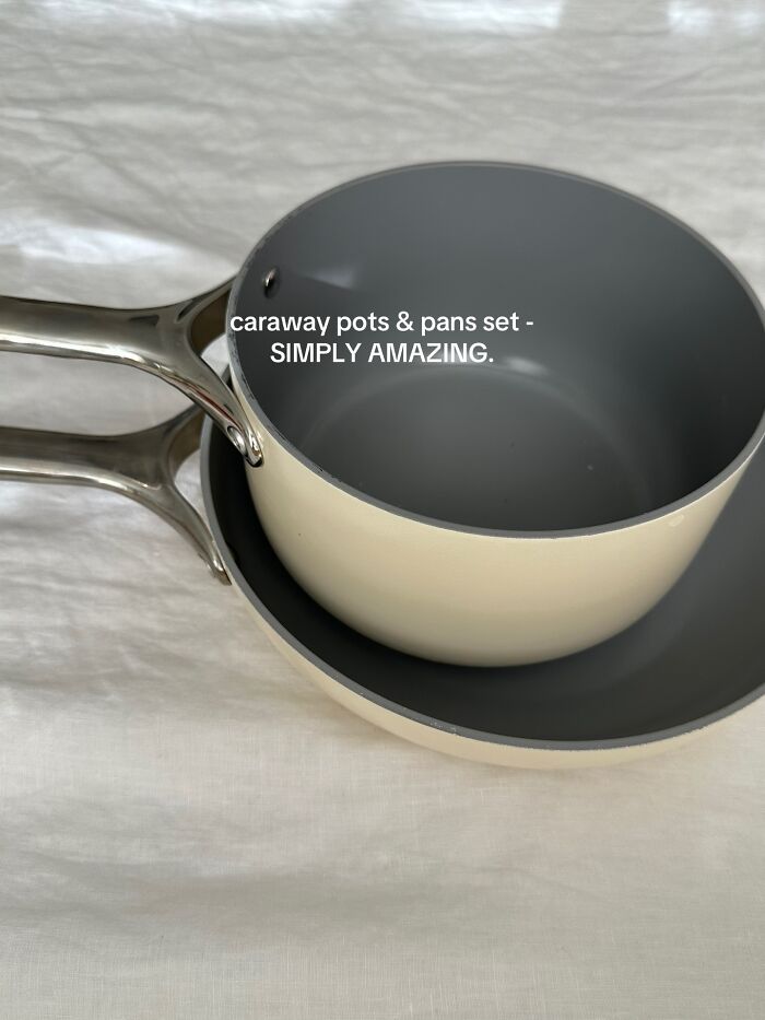 Caraway pots and pans set on white fabric, showcasing a popular Christmas gift recommendation for kitchen use.