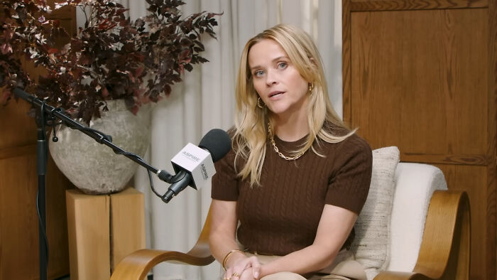 Blonde woman sitting in a chair speaking into a microphone during an interview about running into celebrities.