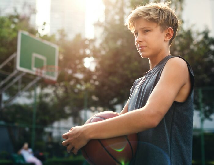 Boy holding basketball on outdoor court, illustrating unique and bizarre names people actually gave their children.