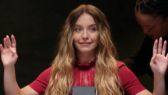 Sydney Sweeney raising hands during a lie detector test, caught in a lie causing public backlash online.