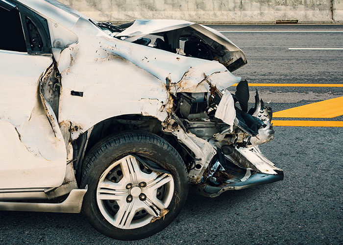 Damaged car after a crash illustrating the dangers and risks of unsafe survival hacks on the road.