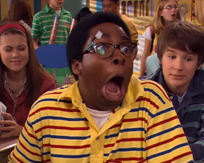 Young man in yellow striped shirt with glasses making a shocked expression as co-star breaks silence on homelessness.