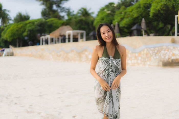 Young woman smiling on a sandy beach representing people who dated outside of their culture experiences.