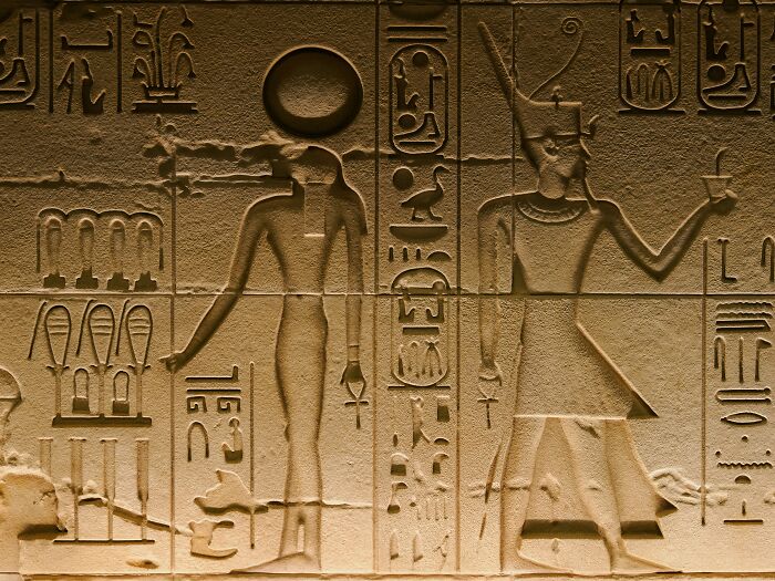 Ancient Egyptian hieroglyphs carved in stone depicting figures and symbols, illustrating crazy facts shared online.