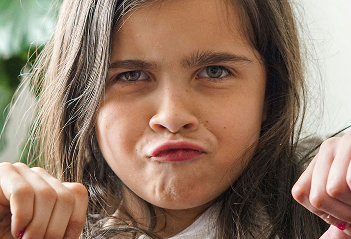 Close-up of a child making a serious face, illustrating disturbing things found in homes of seemingly normal people.