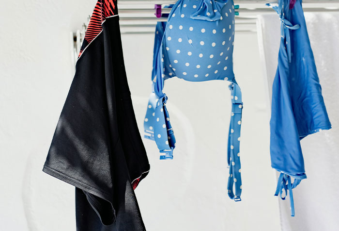 Blue polka dot bikini and black swimsuit hanging to dry, capturing disturbing things found in homes of seemingly normal people.