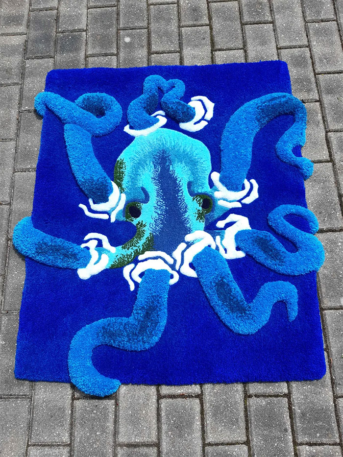 Blue octopus rug with 3D textured tentacles on a gray brick pavement, showcasing cool creative designs people made.