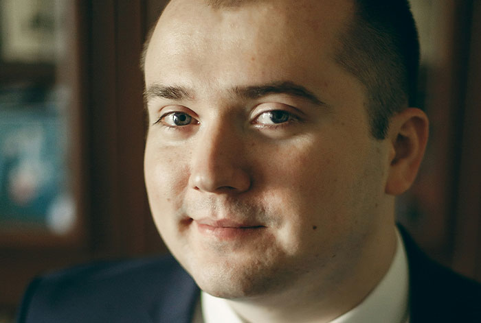 Close-up portrait of a man in a suit, illustrating incredible is anyone here a doctor stories about collapsed lungs on flights.