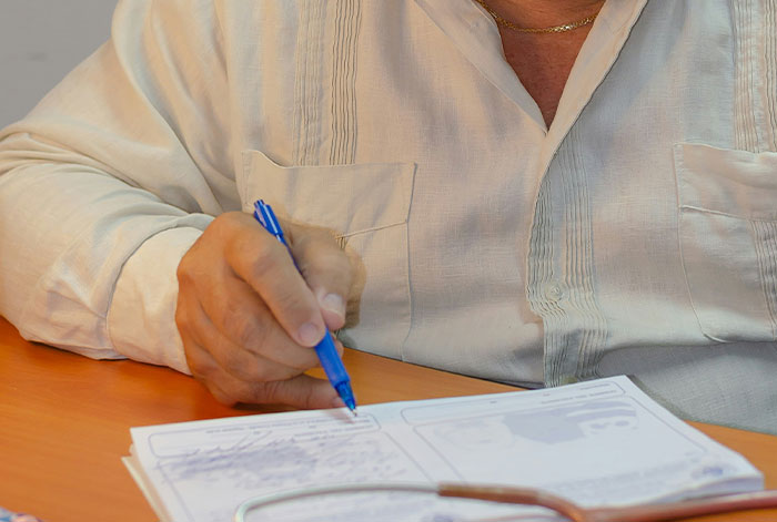 Man in a white shirt writing notes on a medical document, related to collapsed lungs and doctor stories on a flight.