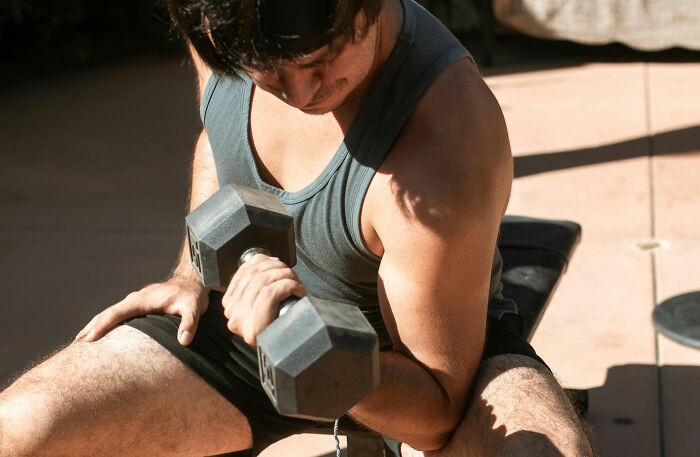 Man lifting dumbbell during workout session focusing on common health concerns that freak people out but are normal