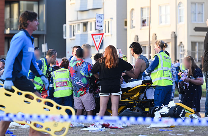 Emergency responders and bystanders assist during a Bondi Beach attack where a woman protects a 3-year-old girl. Emergency responders and bystanders assist during a Bondi Beach attack where a woman protects a 3-year-old girl.