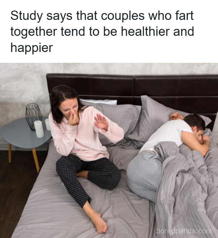 Couple in bed reacting to a funny moment, illustrating interesting psychology facts about relationships and happiness.