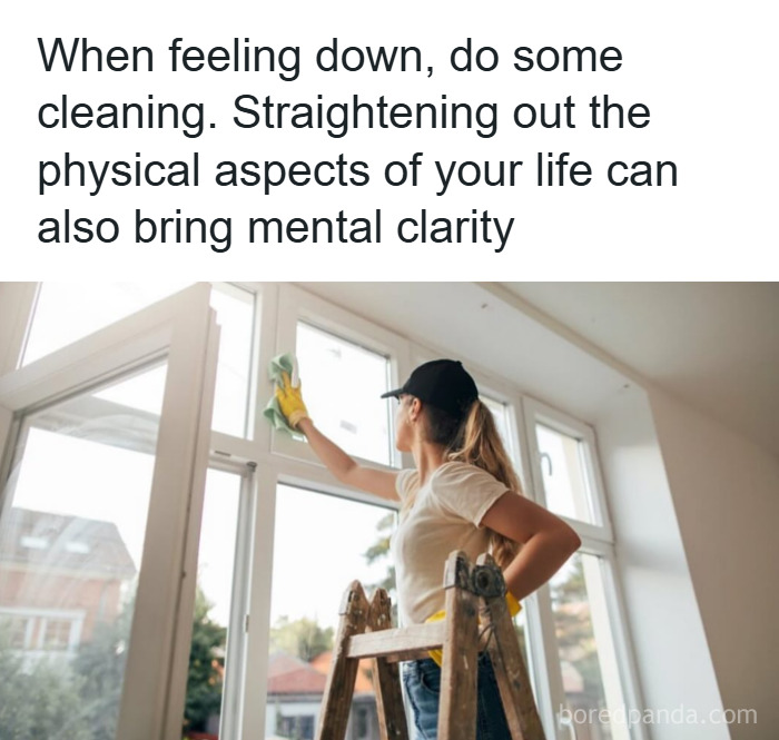 Woman cleaning windows on a ladder, demonstrating psychology facts about mental clarity from organizing physical space.