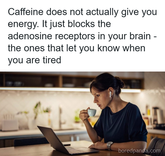 Woman wearing earbuds drinking coffee while working on a laptop, illustrating fascinating psychology facts about caffeine and tiredness.