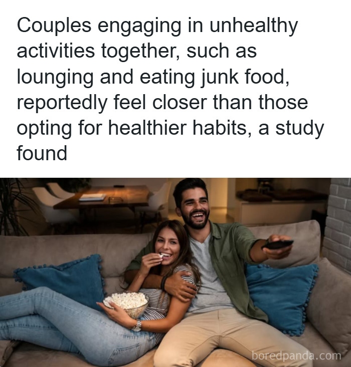 Couple sitting on a couch eating junk food and watching TV, illustrating fun and fascinating psychology facts about habits.