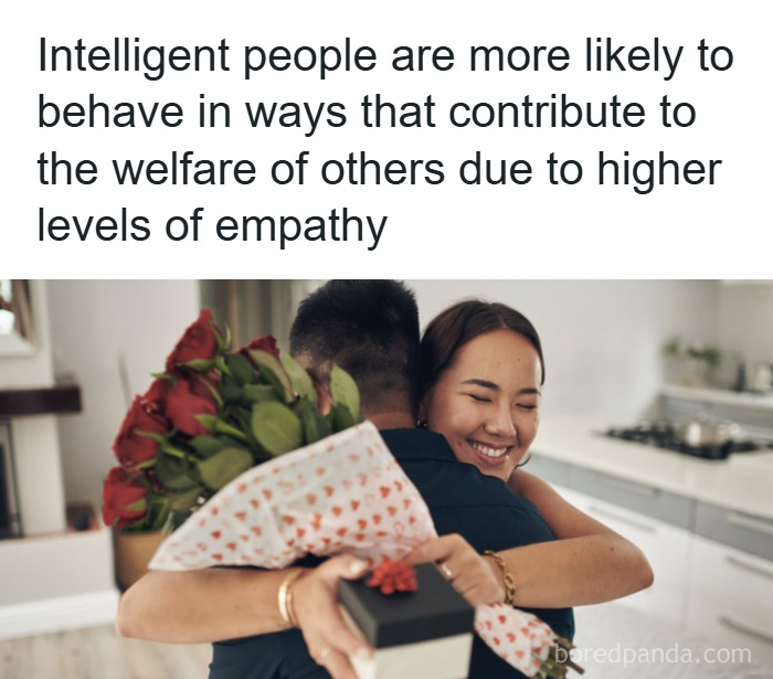 Couple hugging with flowers and gift in kitchen, illustrating empathy and psychology facts about intelligent behavior.