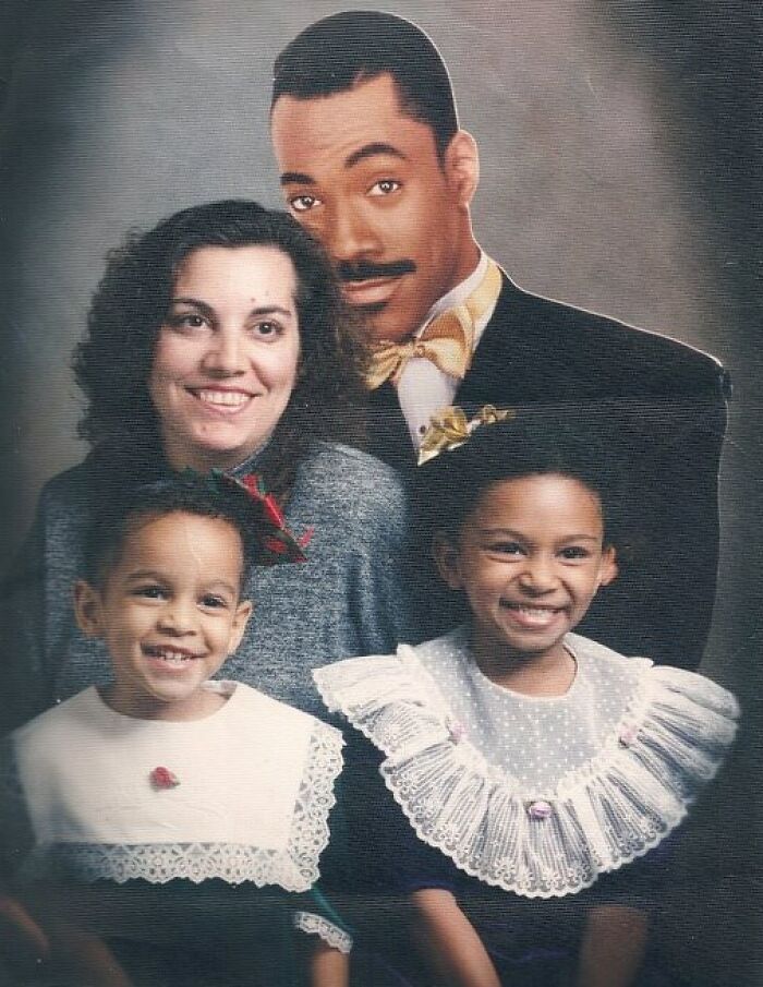 Awkward family Christmas photo with parents and children dressed in vintage formal attire smiling for the camera.