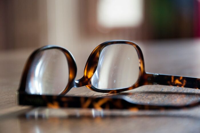 Close-up of tortoiseshell glasses on a wooden surface, symbolizing moments when people instinctively knew to leave.
