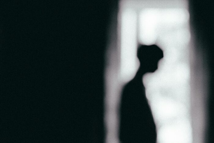 Silhouetted person standing near a bright window, representing moral compass challenges and facing shocking dilemmas.