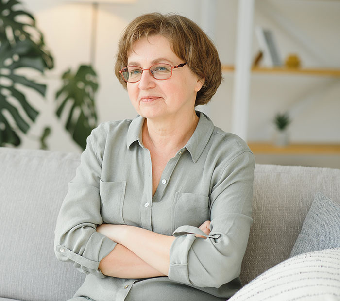 Older woman sitting on a couch with a confident expression, depicting grandma’s savage holiday clapback vibe. Older woman sitting on a couch with a confident expression, depicting grandma’s savage holiday clapback vibe.