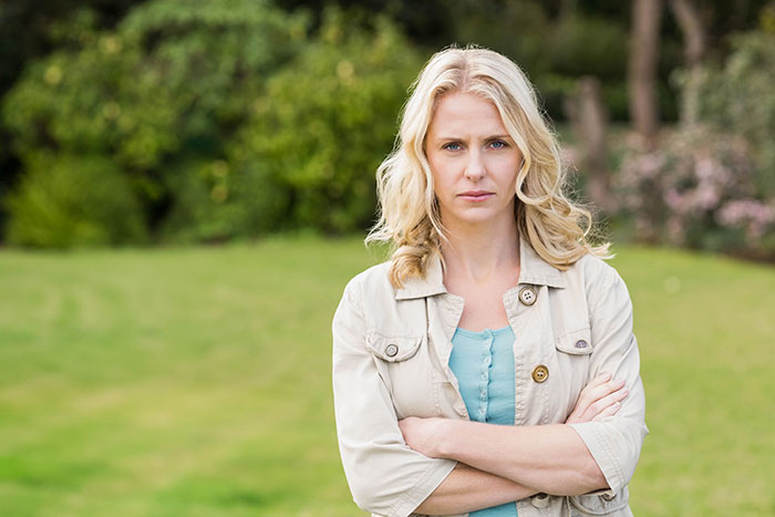 Angry woman standing outdoors with arms crossed, reflecting grandma’s savage holiday clapback mood. Angry woman standing outdoors with arms crossed, reflecting grandma’s savage holiday clapback mood.