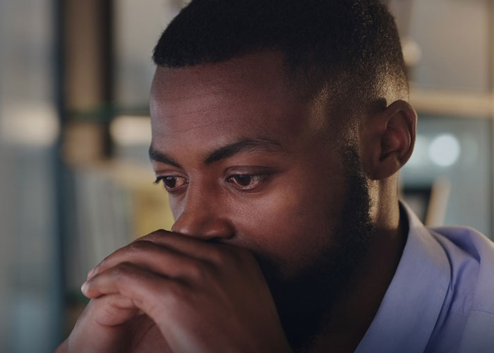 Man with a beard looking thoughtful and sad, reflecting on being left without closure after fiancé disappears before wedding.