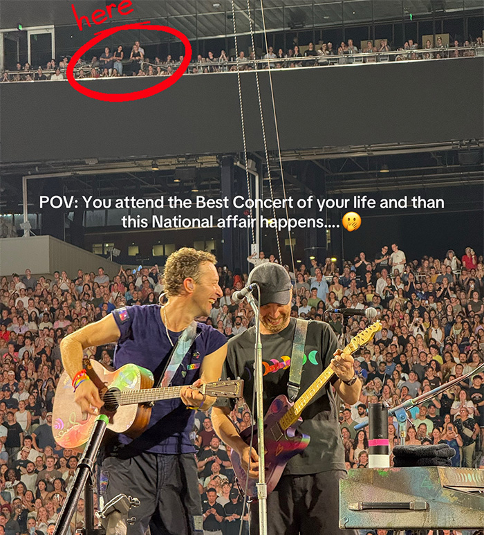 Coldplay performing live on stage at a concert with large crowd and a highlighted spectator in the balcony.